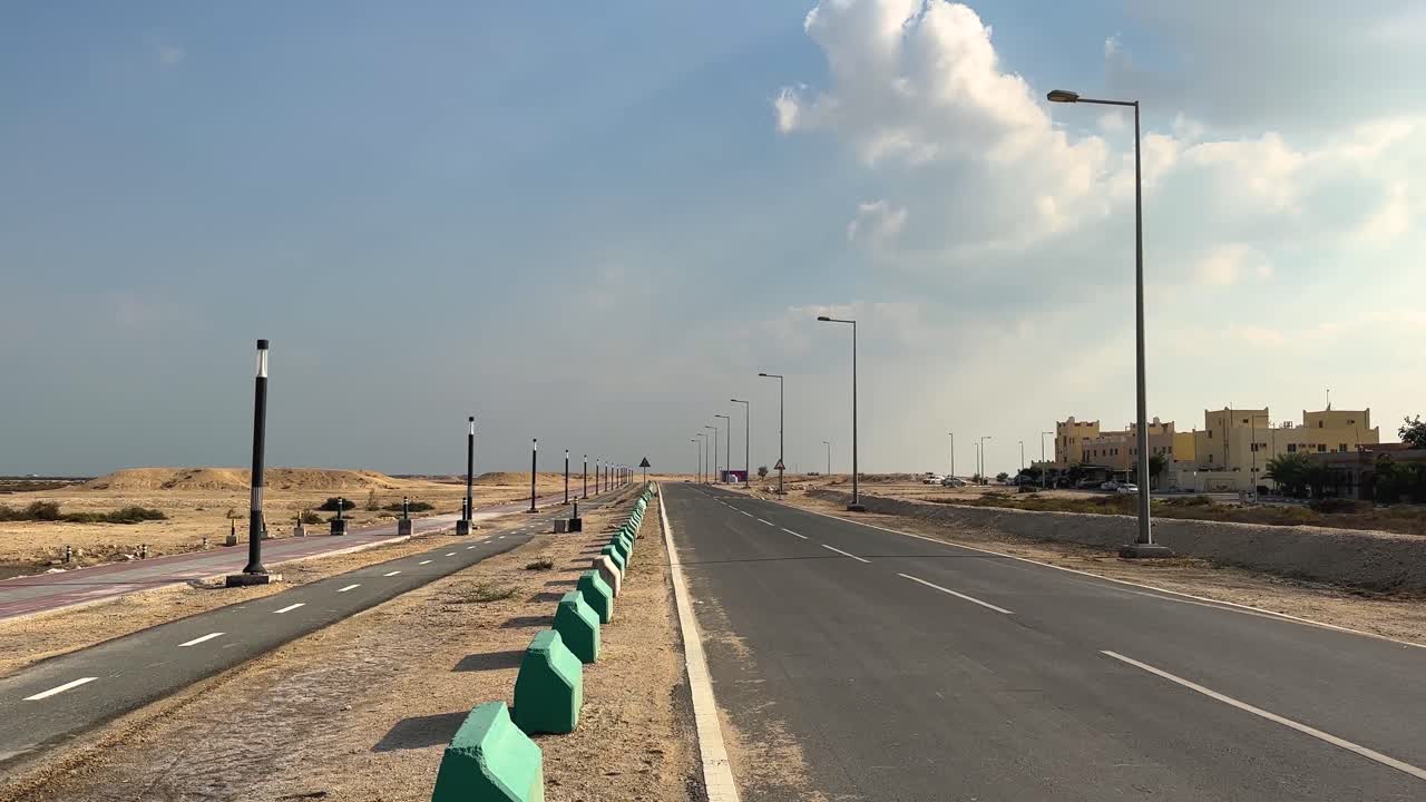 Abandoned desert road easy to see and visit in Emirates Qatar Saudi Arabia street light perspective settlement alone lonely tree in a calm relaxing place sun shine unlimited perspective clouds in sky