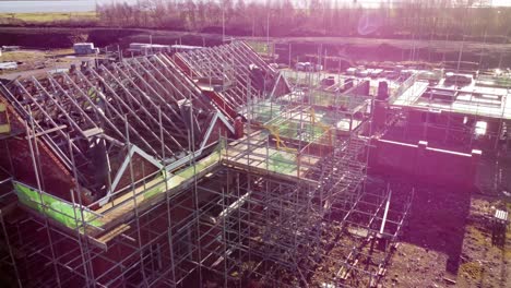 Unfinished-townhouse-property-scaffolding-framework-on-builders-construction-site-aerial-view