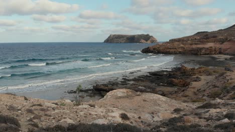 Olas-Rompiendo-Contra-Las-Playas-De-Piedra-Caliza-De-Porto-Santo-Con-Otra-Isla-En-La-Distancia