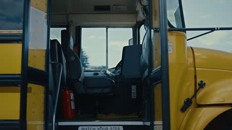 school bus entrance open on empty stop without students driver close up.