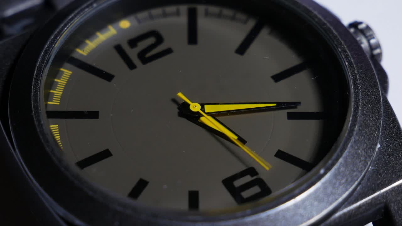el movimiento de las manecillas amarillas de un reloj de pulsera