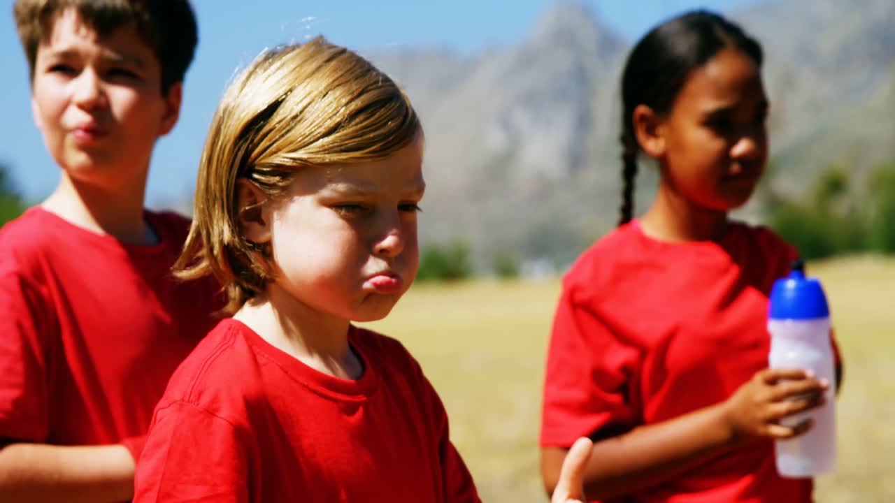 niños bebiendo agua en el campamento de entrenamiento