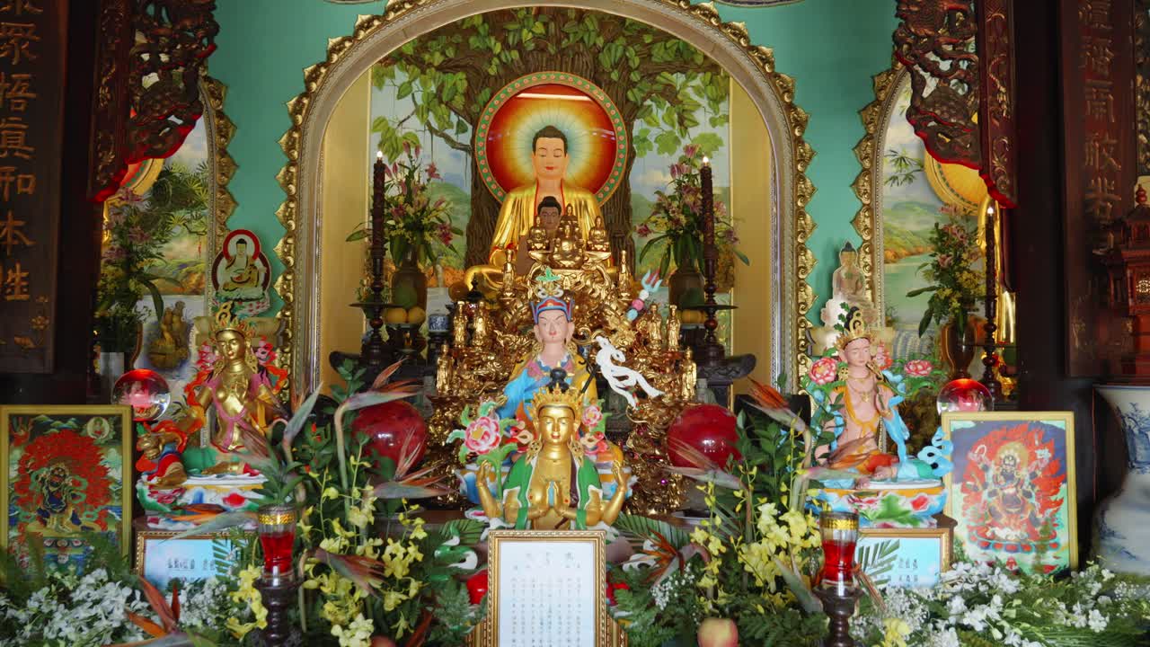un colorido altar budista con múltiples figuras de buda, incluida una gran estatua de buda con una aureola