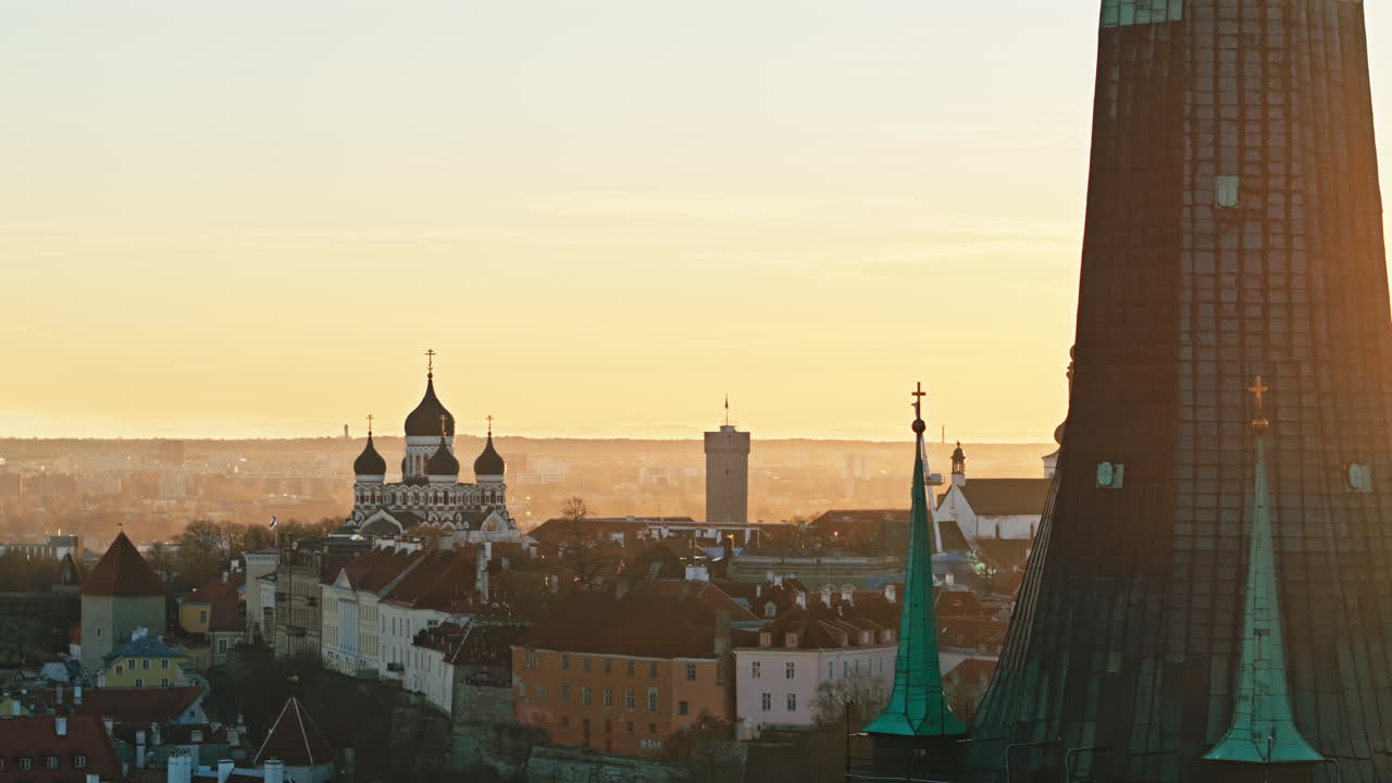 Vista aerea in sorvolo della città vecchia di Tallinn con la torre della chiesa di Sant'Olav in primo piano e l'edificio governativo Stenbock in un bellissimo tramonto estivo.