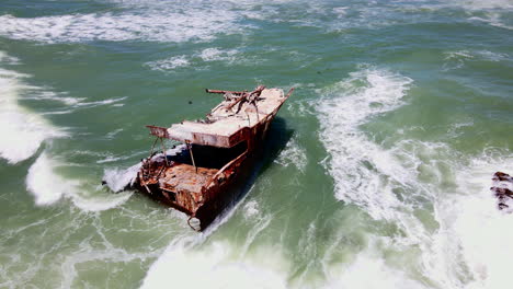 drone orbit around weathered shipwreck on cape agulhas coastline, overberg