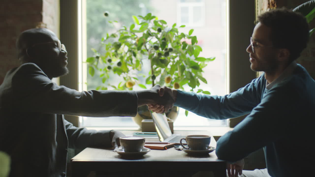 Business Partners Shaking Hands on Coffee Meeting in Cafe