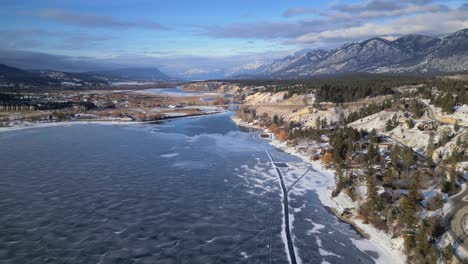 vista aérea de drones del lago windermere congelado pasando a lo largo de la costa sureste con patinadores de hielo y pistas artificiales hechas en el hielo debajo