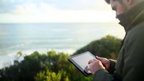 a young man using a tablet outdoors