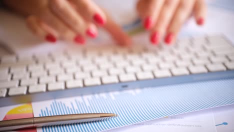 transcriber typing on computer keyboard near graphics and pen closeup 4k movie
