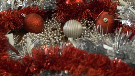 woman picking up christmas bauble to hang xmas decorations