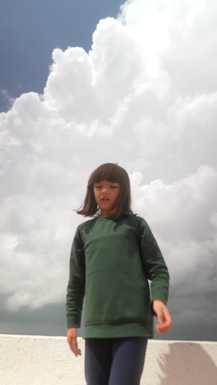 Child Dancing Under a Cloudy Sky