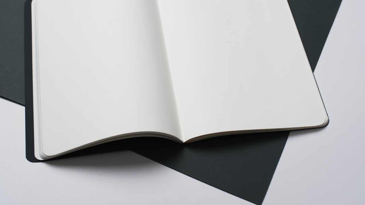 Video of book with white blank pages and copy space on black and white background