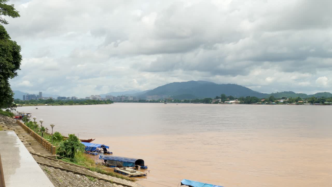 Panoramic view of the Mekong River with Laos visible across from Thailand, showcasing calm water, riverside settlements, and distant mountain scenery