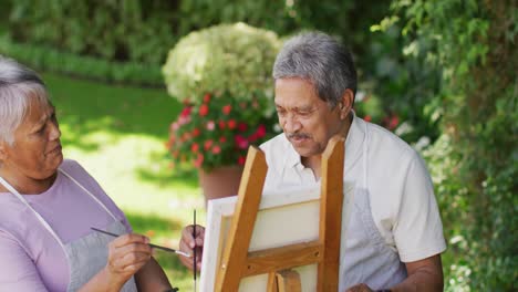 Video-of-happy-biracial-senior-couple-painting-in-garden