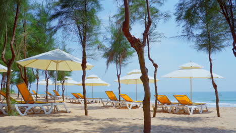 Tropischer-Natursandstrand-Und-Meereswelle-Mit-Gelber-Strandbank-Unter-Weißem-Sonnenschirm-Und-Bäumen-Am-Tropischen-Inselstrand