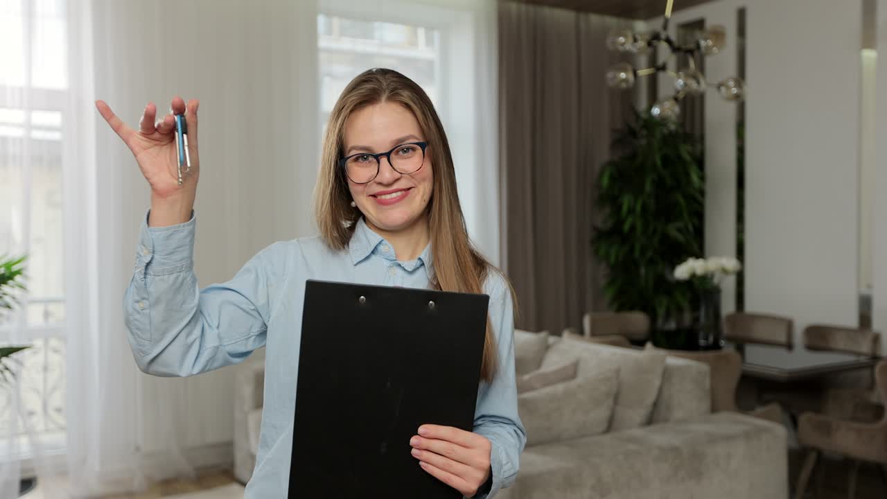 Portrait of happy, friendly real estate agent in apartment. Real Estate Agent is giving the keys to an apartment to clients. Professional saleswoman real estate broker.