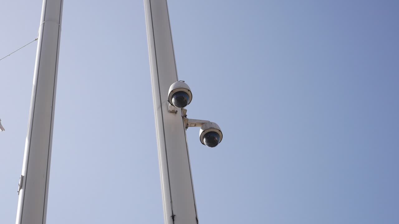 Due telecamere di sicurezza montate su un palo bianco