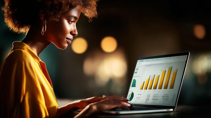 Focused analysis of growth metrics and data trends by a young professional, showcasing business intelligence through graphs and visualizations on a laptop screen in a modern workspace