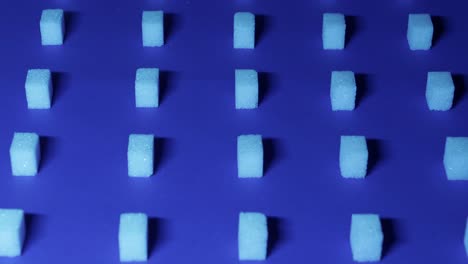 4K-tilt-down-view-of-a-unique-cubic-background-with-white-sugar-cubes-arranged-in-rows-on-a-dark-blue-background,-3D-effect