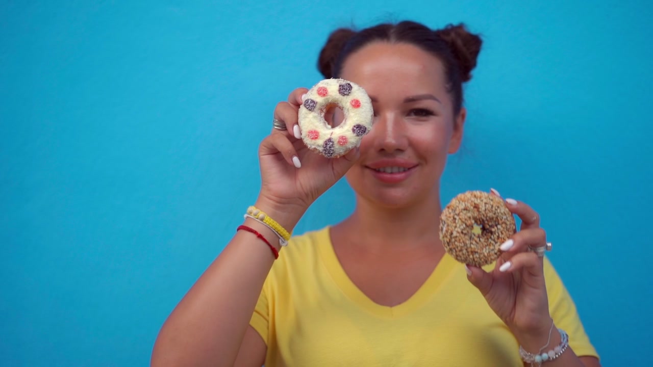 Young Woman Holding and Playing with Glazed Donuts