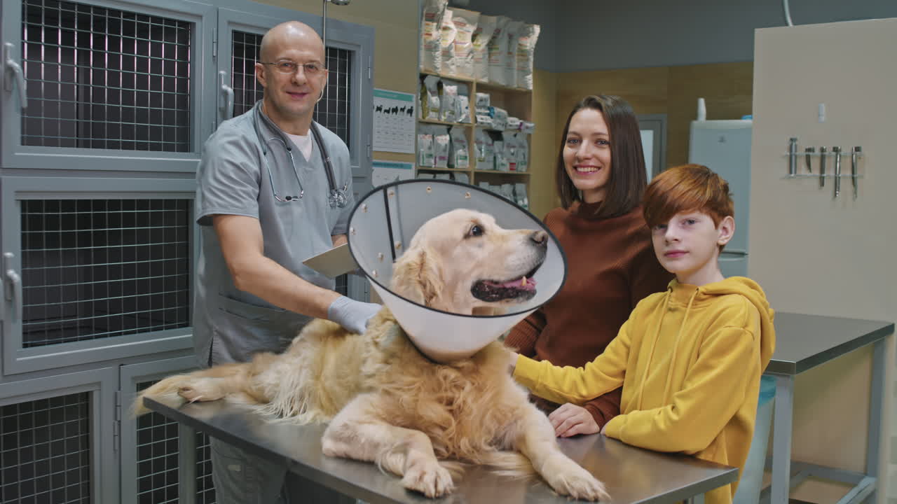 Portrait Of Veterinarian With Dog And Its Owners