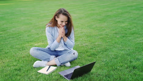 Mujer-Feliz-Trabajando-En-Una-Computadora-Portátil-En-El-Césped-Verde-En-El-Parque-De-Verano