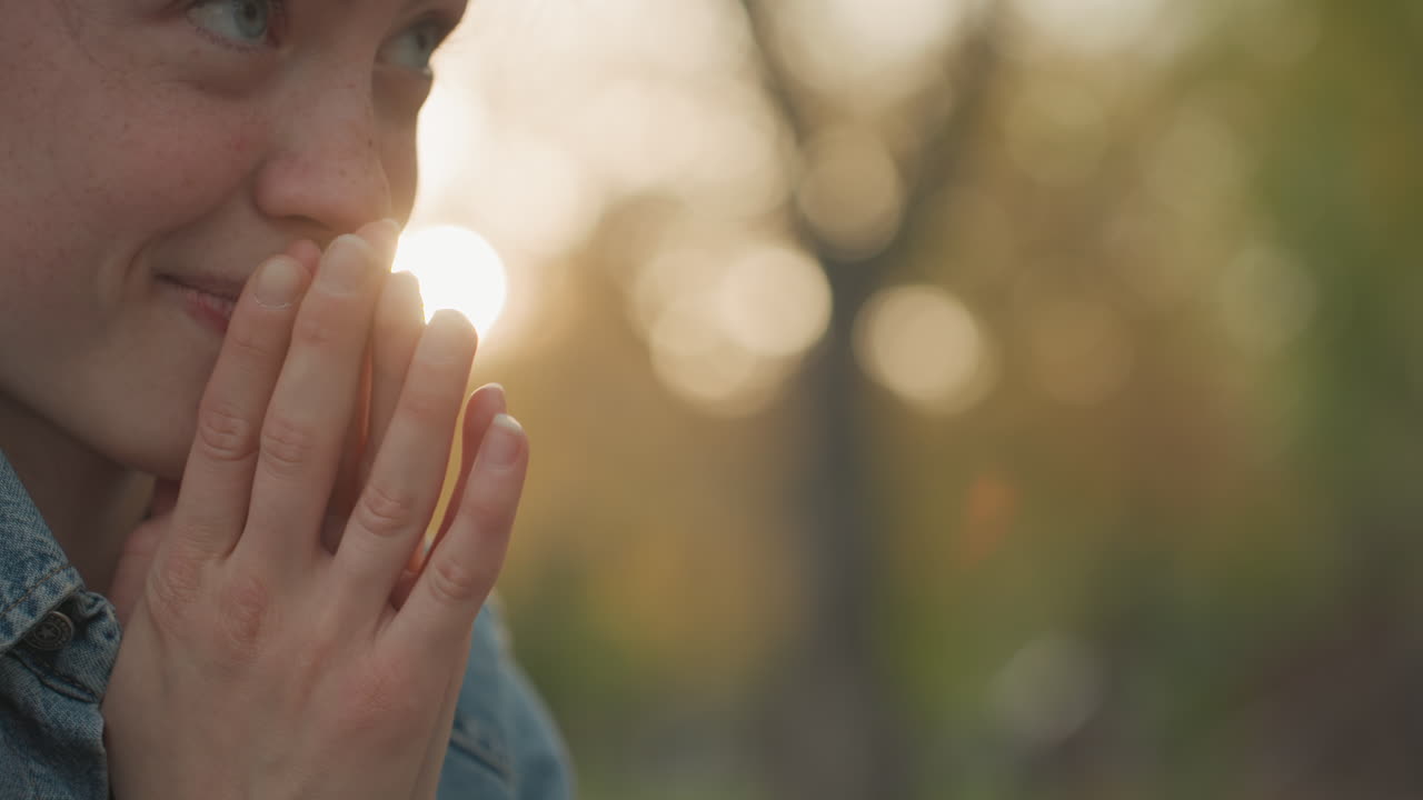 Gioiosa celebrazione nel parco. Una donna entusiasta e i suoi amici celebrano la felicità alla luce del sole all'aperto. La donna applaude con entusiasmo insieme agli amici sotto la luminosa luce solare durante una festività all'aperto.