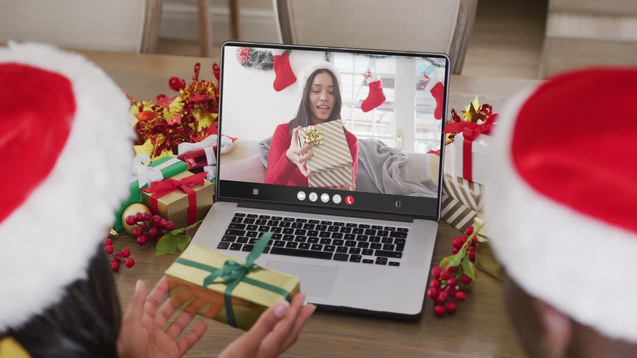 una pareja diversa tiene una llamada de video de navidad con una mujer biracial.