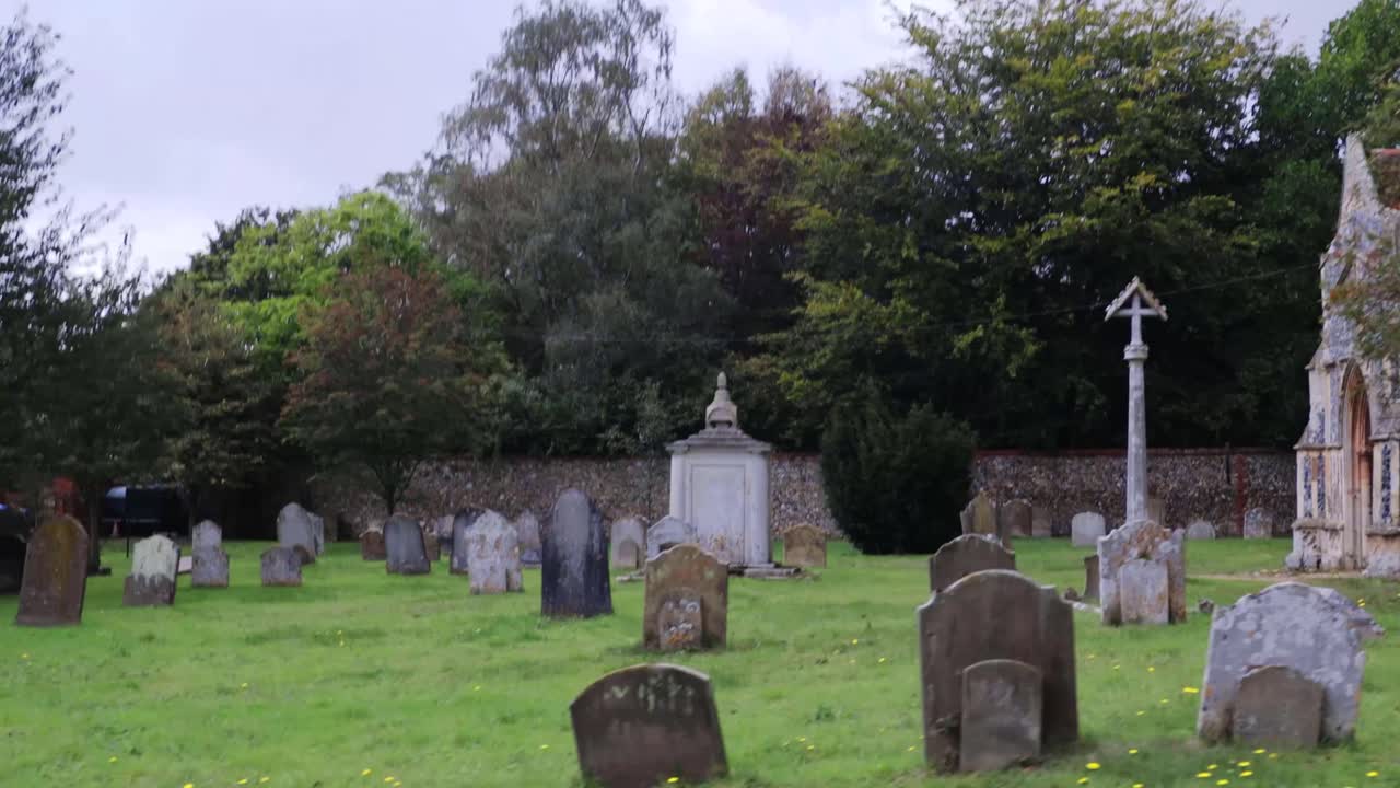 seguimiento de derecha a izquierda a través de la iglesia de inglaterra cementerio en un pequeño pueblo
