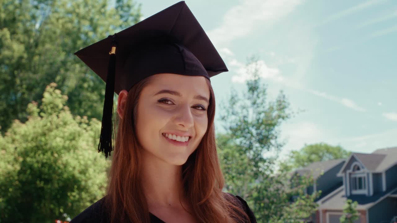 A female graduate student turns her head and smiles at the camera. Low Angle.