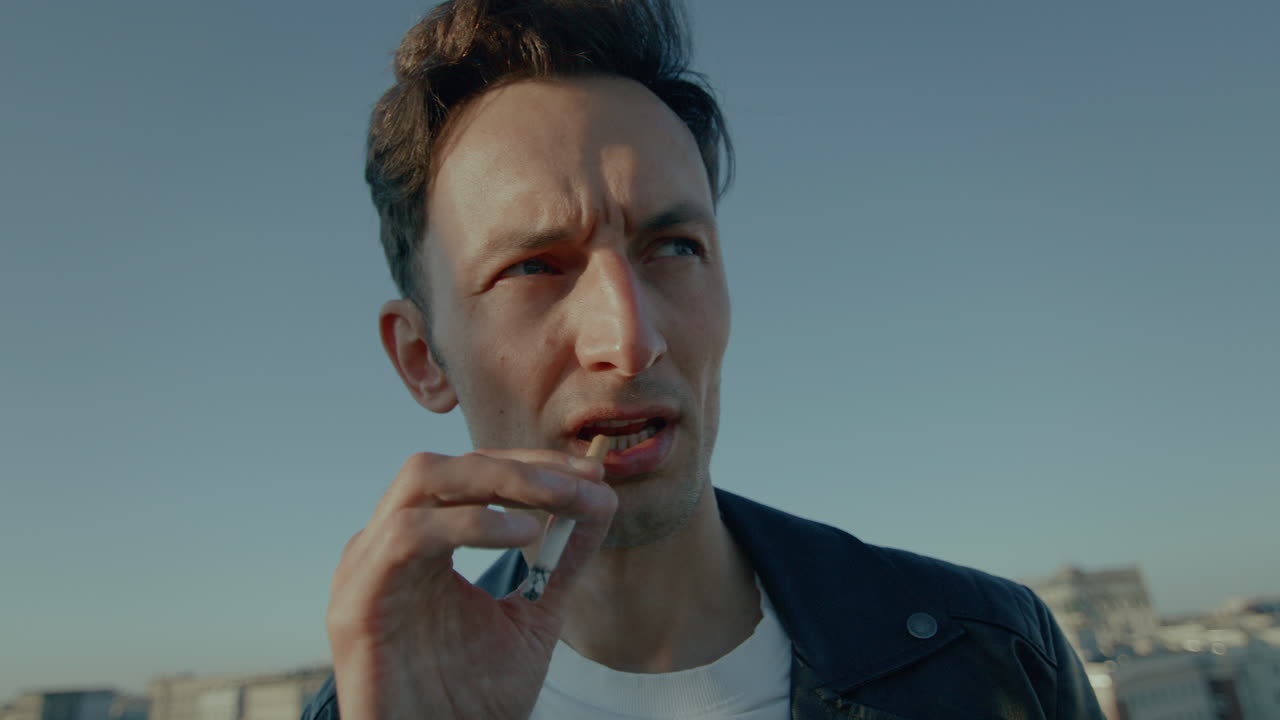 담배를 피우는 젊은 남자, 검은 가죽 재, 즐기고, 연기를 불어, 느린 동작