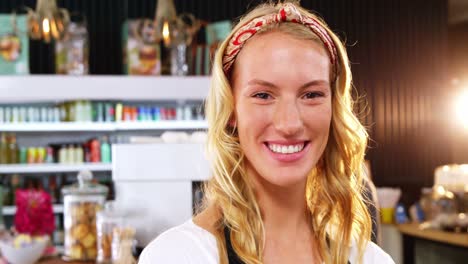 portrait of smiling waitress standing with arms crossed