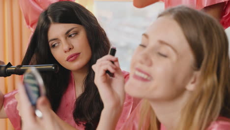 Close-Up-View-Of-Two-Female-Friends-Making-Up-And-Combing-For-The-Wedding