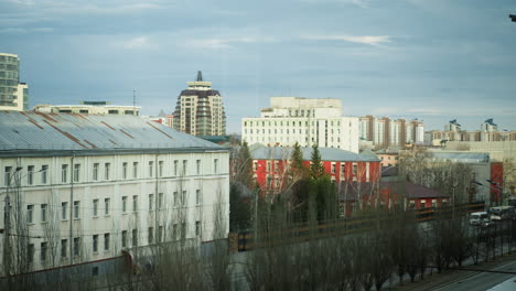 vista cercana de un paisaje urbano con varios edificios, incluidas estructuras residenciales y comerciales, con coches que se ven moviendo en las calles de abajo