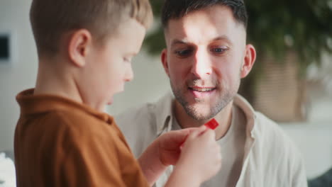 little boy plays with his dad and talks on the couch during christmas