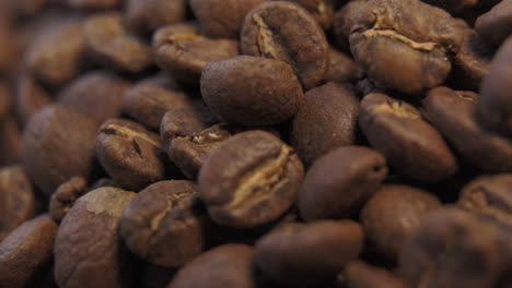 vista macro cercana de granos de café marrones recién tostados que se utilizarán para café negro caliente girando a la izquierda