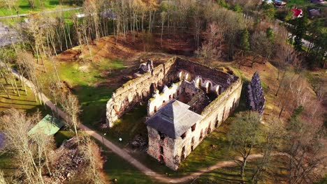 aerial establishing shot tilting down towards rauna castle, a medieval castle in latvia