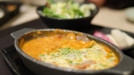 Rose-cheese-potato-gratin-picked-up-with-fork-in-fusion-French-restaurant---close-up-slow-motion