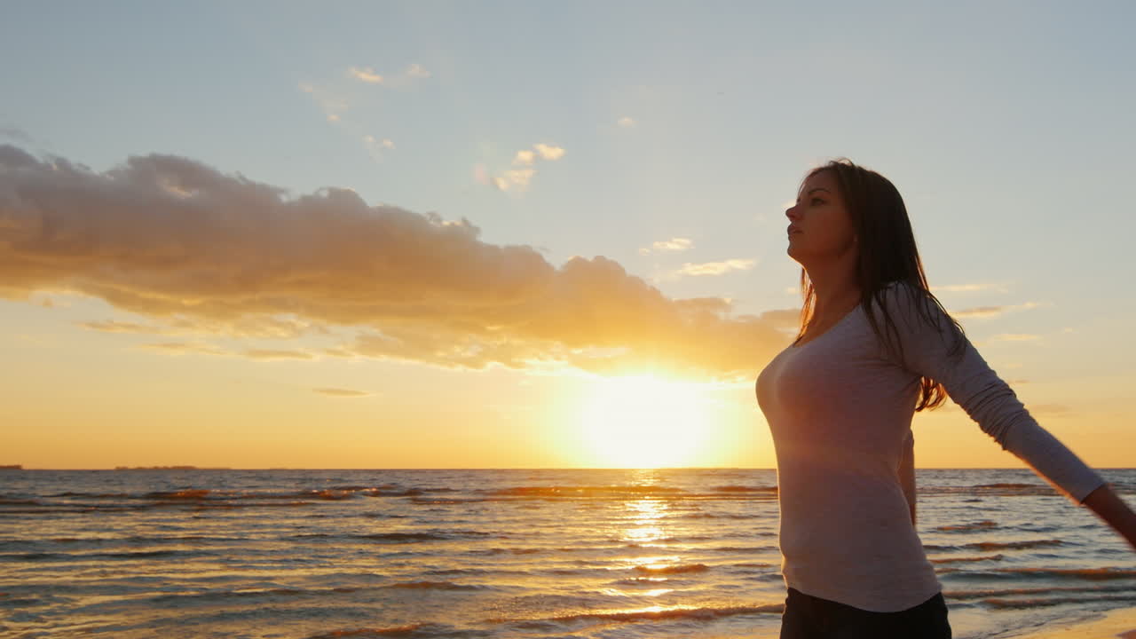 해질녘 해변에서 저녁 조깅을 하기 전에 워밍업을 하는 아름다운 몸매를 가진 젊은 여성