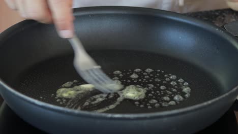 Toma-De-Primer-Plano-Del-Hombre-De-Mantequilla-Derritiendo-Mantequilla-En-Una-Sartén-Moderna-Negra-Eléctrica-Y-Poniendo-Dos-Filetes-De-Carne-Molida-Cruda,-Todavía-De-Primer-Plano-Medio