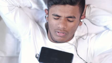 man relaxing with headphones and smartphone