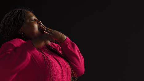 Woman-Yawns-On-Isolated-Black-Background