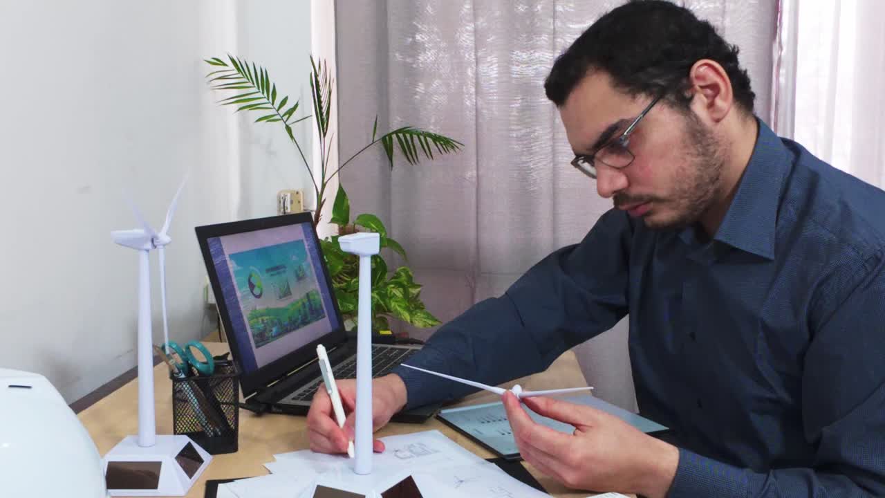 Ingeniero anotando un plano mientras ensambla un modelo de turbina