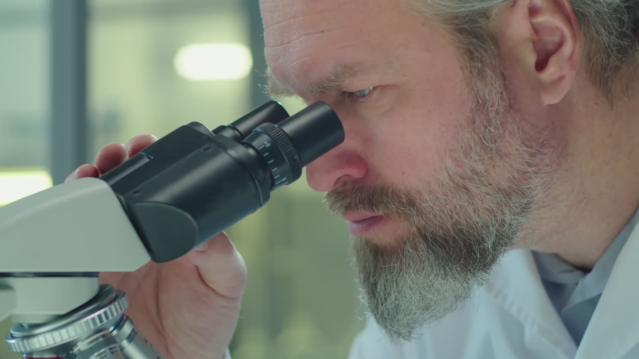 Mature Scientist Working with Microscope