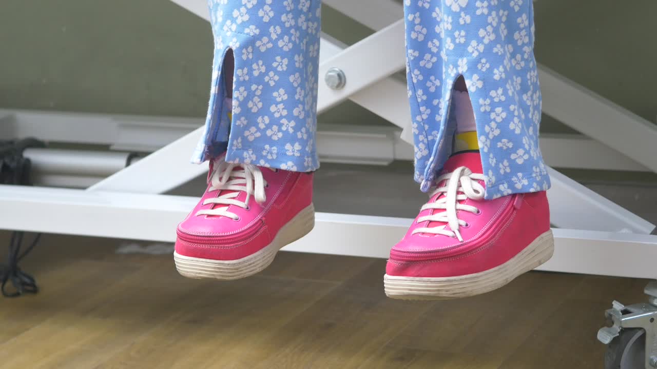 Person sitting on a lift with pink shoes