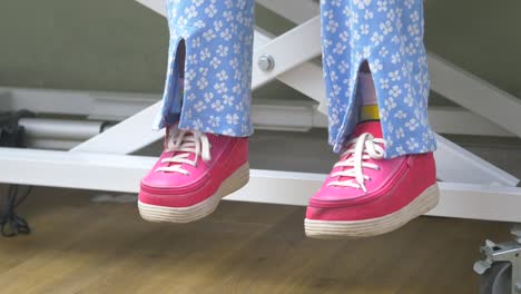 person sitting on a lift with pink shoes