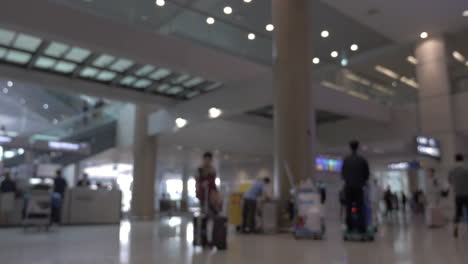 People-with-baggage-and-carts-in-airport-terminal