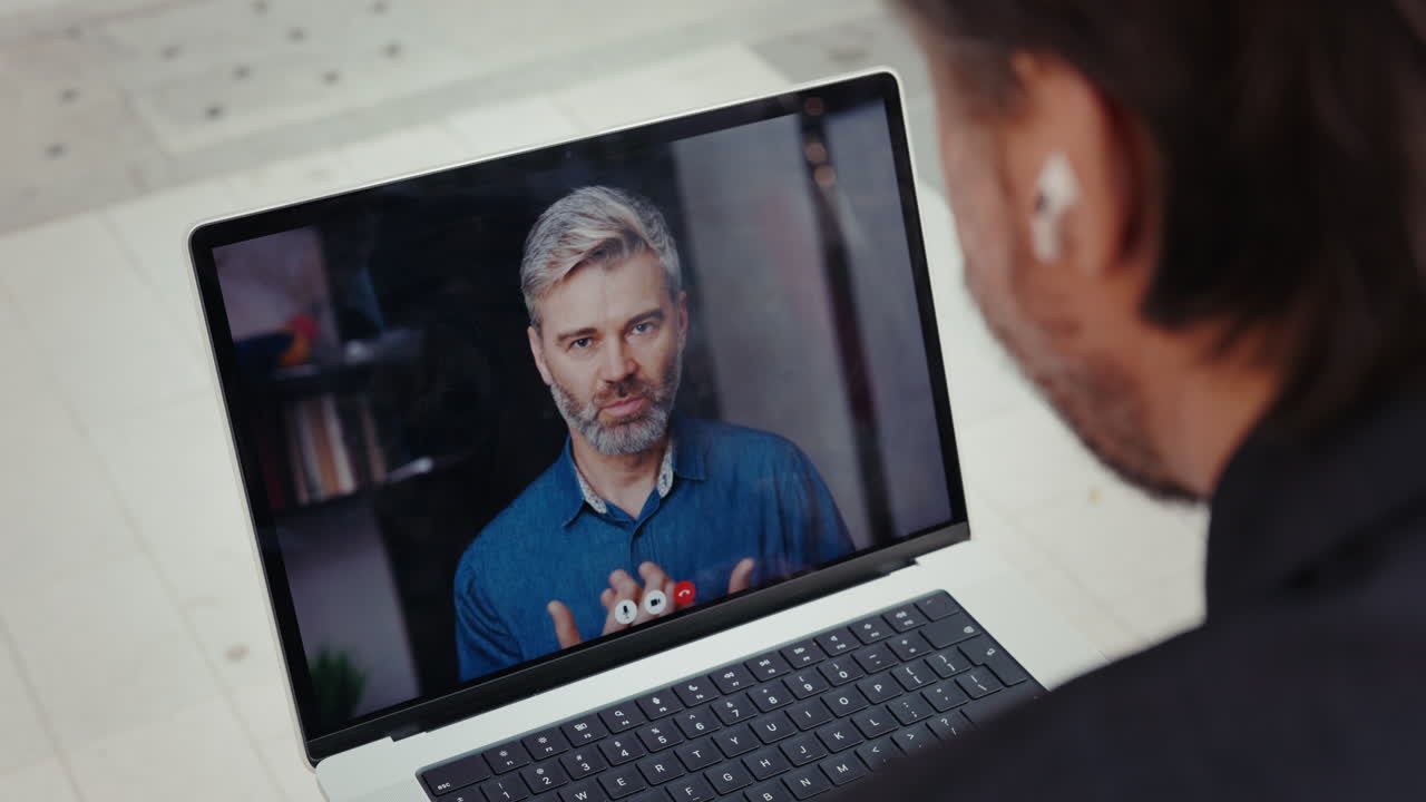 Over Shoulder View of Man on Video Call on Laptop