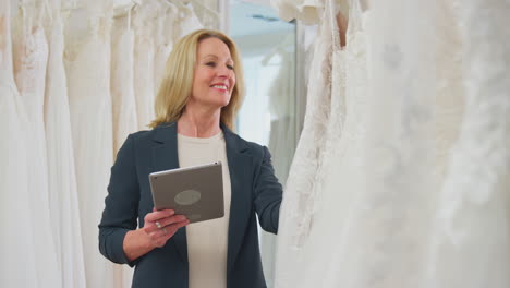 Mujer-Madura-Propietaria-De-Una-Tienda-De-Vestidos-De-Novia-Con-Tableta-Digital