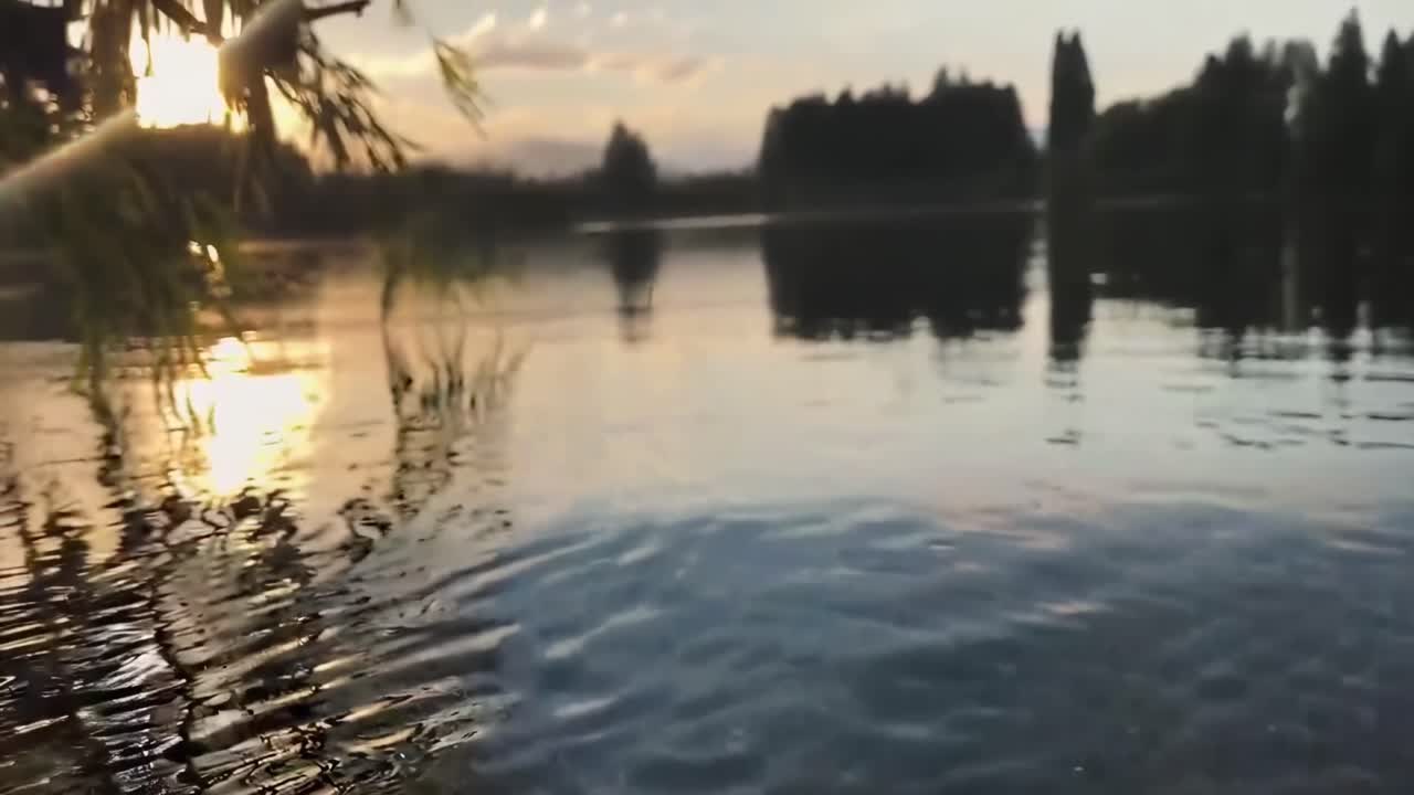 Tranquil video of rippling water at sunset, captured from a low angle, serene and calming